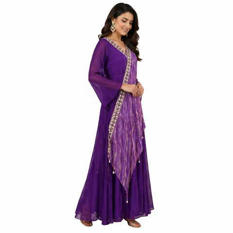 Woman in a purple traditional outfit with a decorative shawl in a stylish interior setting.