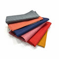 Stack of colorful fabric swatches on a light surface