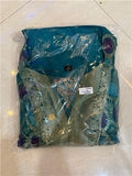 Blue and green patterned fabric in clear plastic wrap on a light-colored floor.